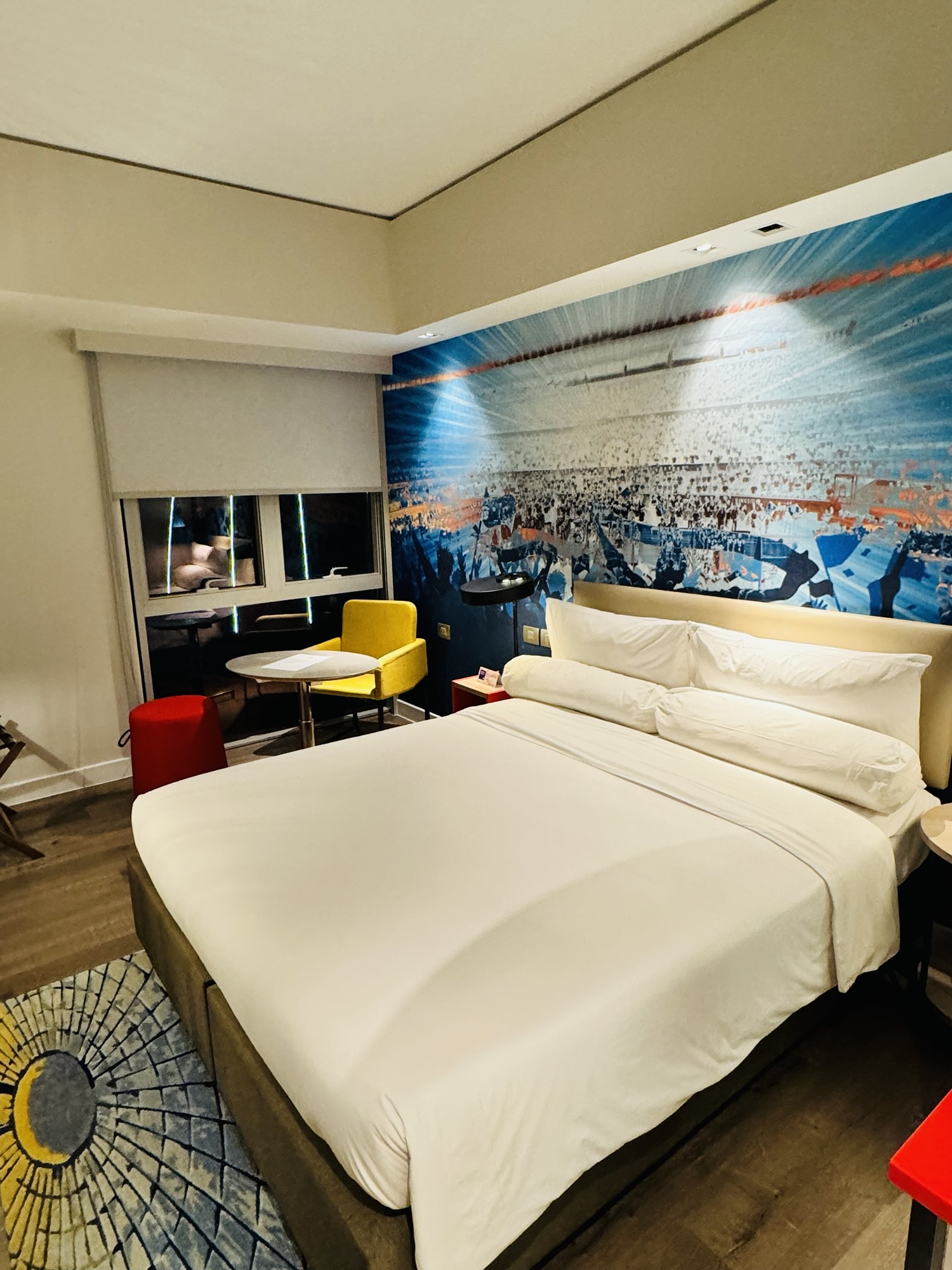 スタジアムのコンサートを思わせる壁画とベッド