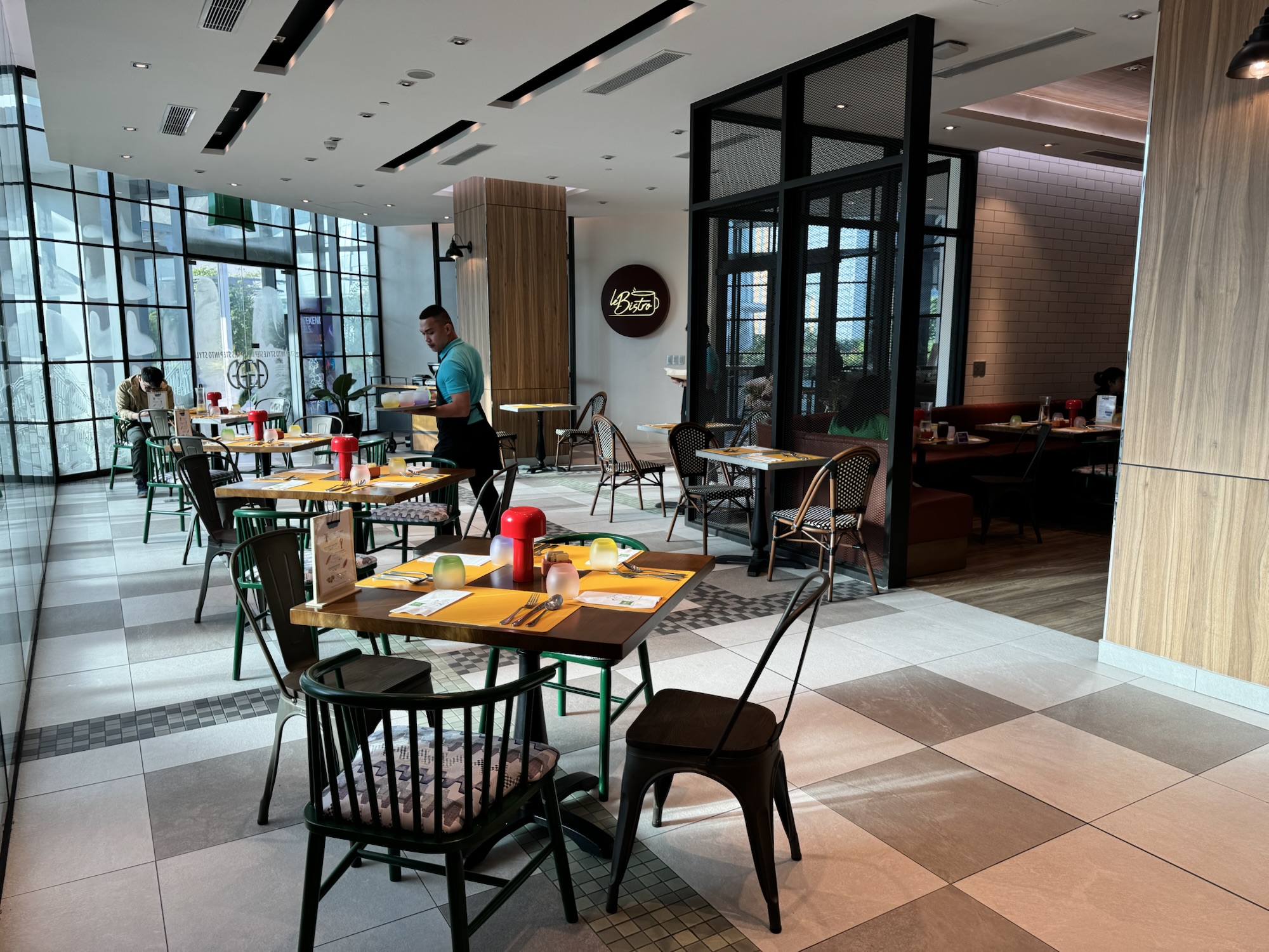 Le Bistroの日中のレストラン、大きな窓とビストロ風の椅子
