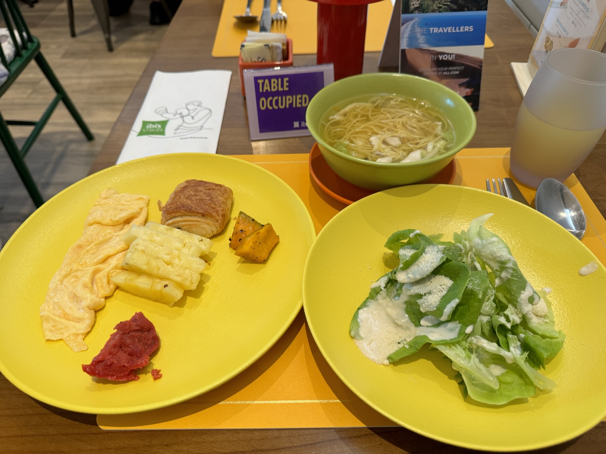 オムレツ、クロワッサン、サラダ、ヌードルスープの朝食プレート