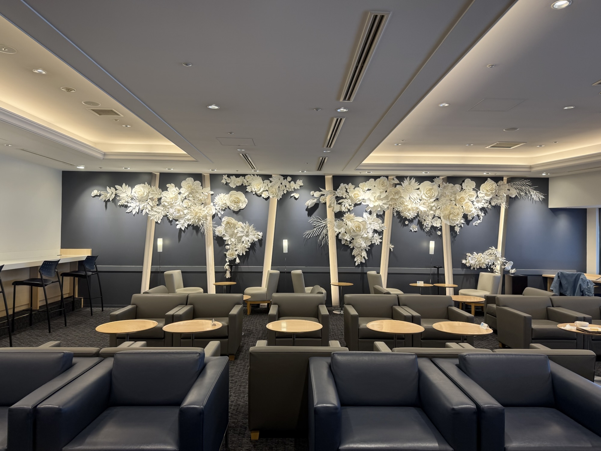 NARITA PREMIER LOUNGEの花のウォールアートと座席エリア
