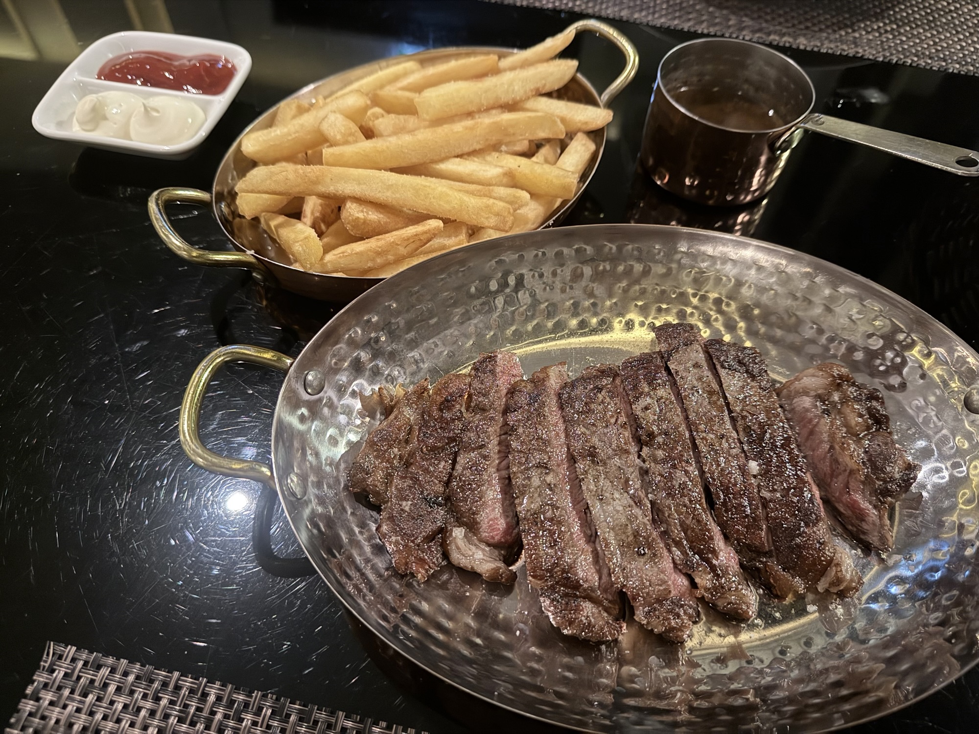 銀皿に盛られたスライスステーキと、別皿のフライドポテト