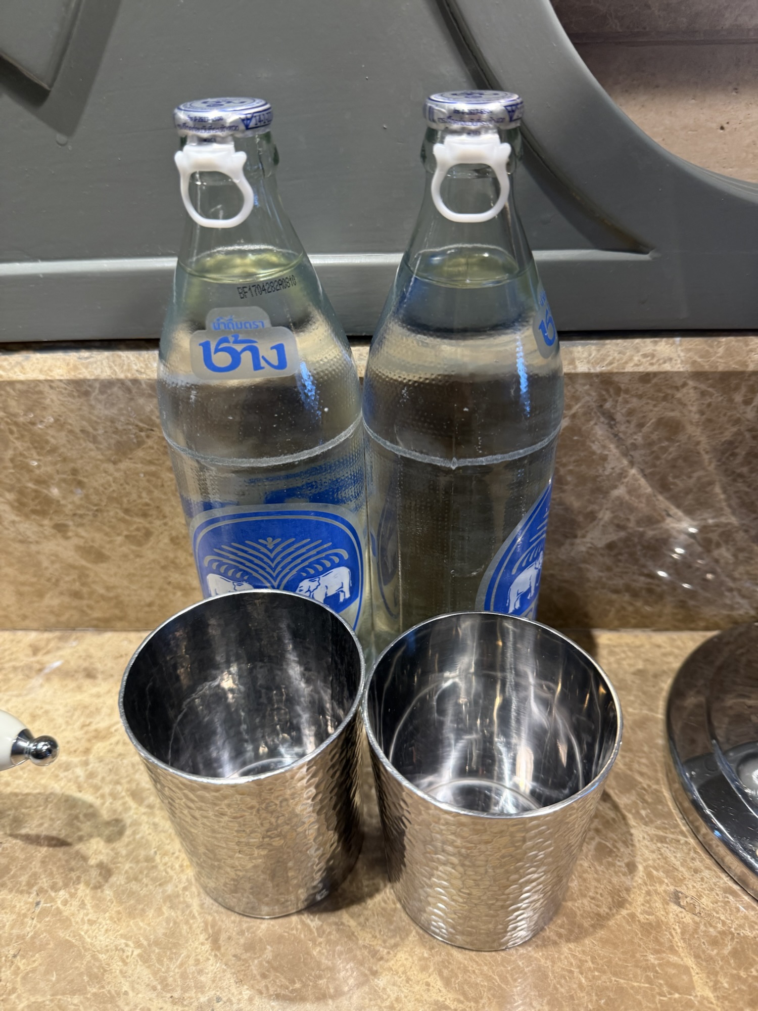 客室に用意されたガラス瓶入りの飲料水とタンブラー